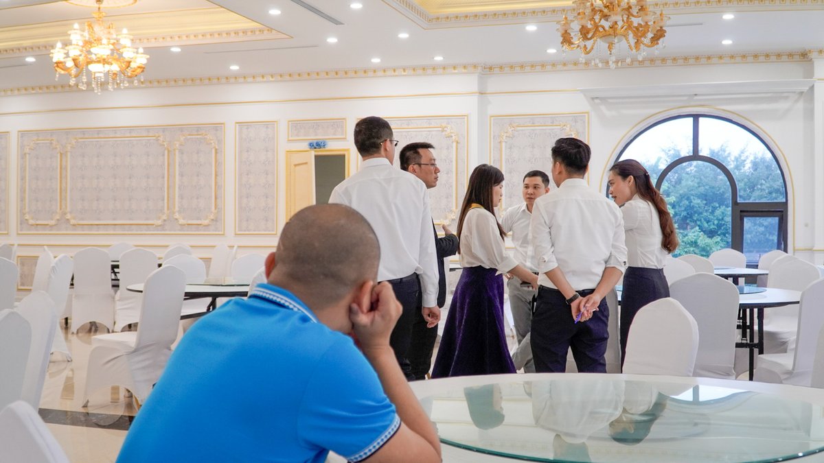 Một người ngồi một góc nhìn nhóm doanh nhân đang trò chuyện, minh hoạ nỗi ngại bắt chuyện với người lạ