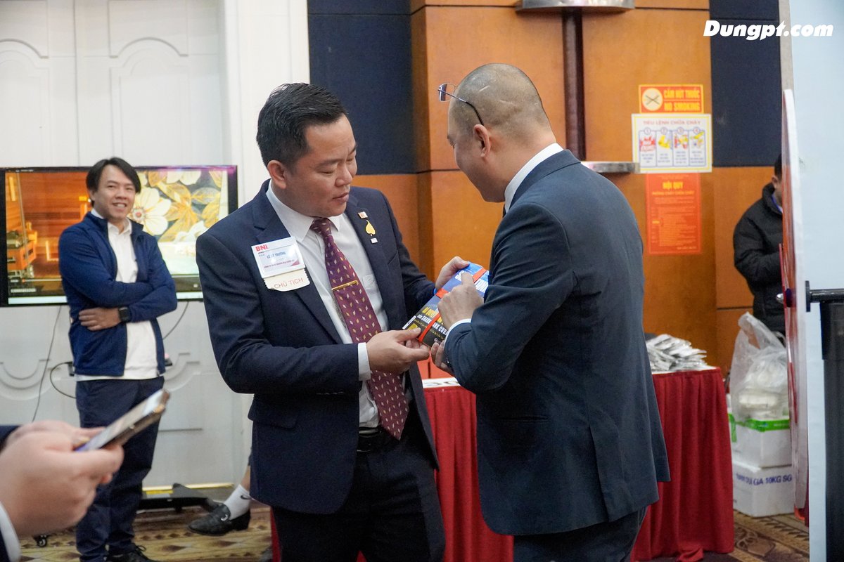 Cách bắt chuyện với người lạ trong sự kiện Hai doanh nhân bắt chuyện tự nhiên trong sự kiện, minh hoạ cách bắt chuyện với người lạ khi networking